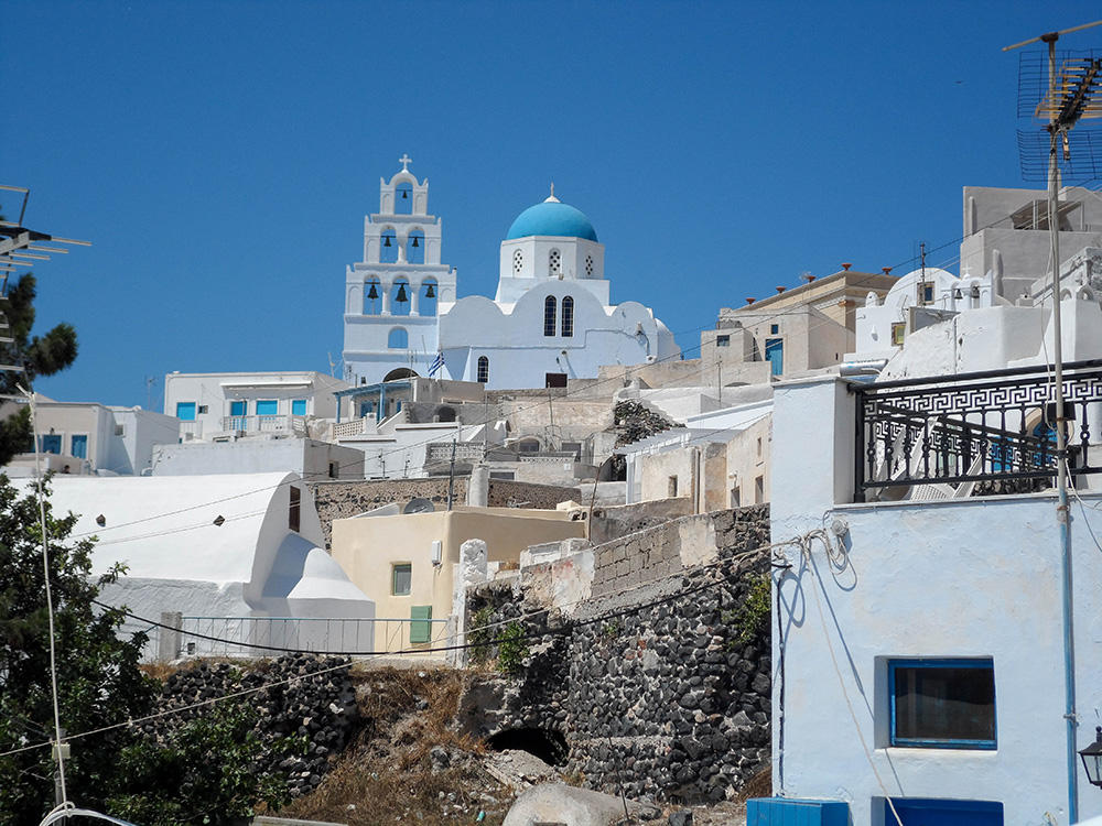 whitewashed buildings with blue dome roofs in Santorini