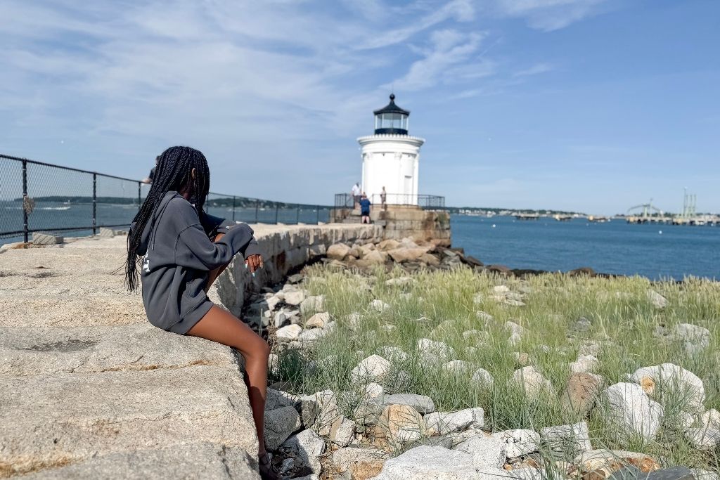 girl looking towards Bug Light in Portland, Maine