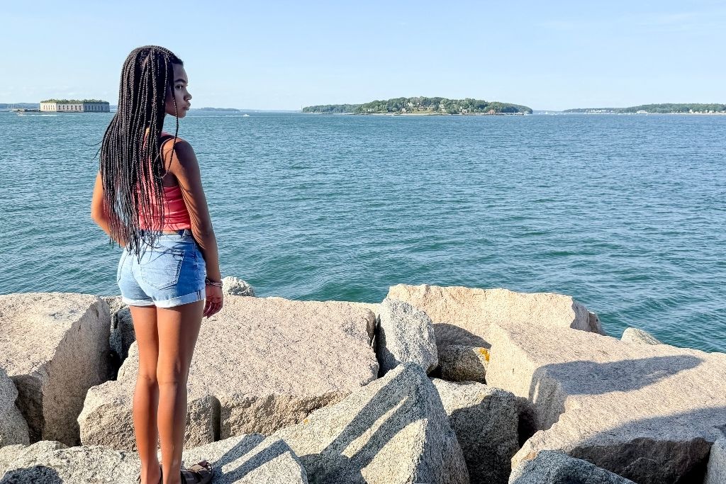 girl looking out over the water at Breakwater Light in Portland